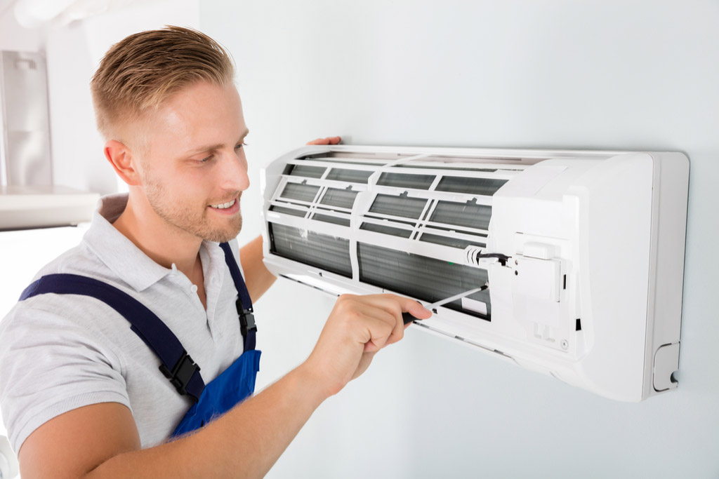 HVAC technician performing ductless air conditioning maintenance in Salt Lake City