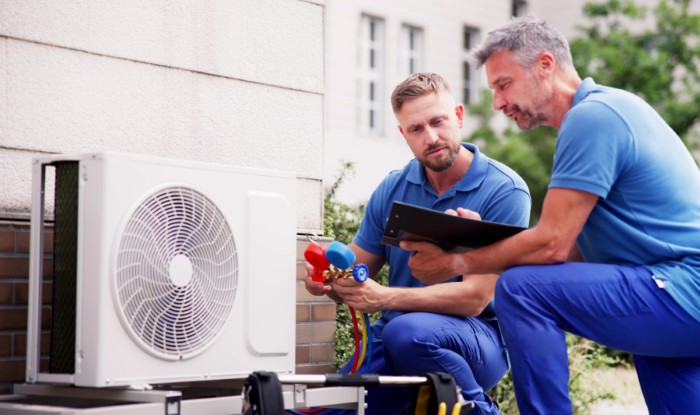 HVAC technicians installing an outdoor air conditioning unit in Salt Lake City