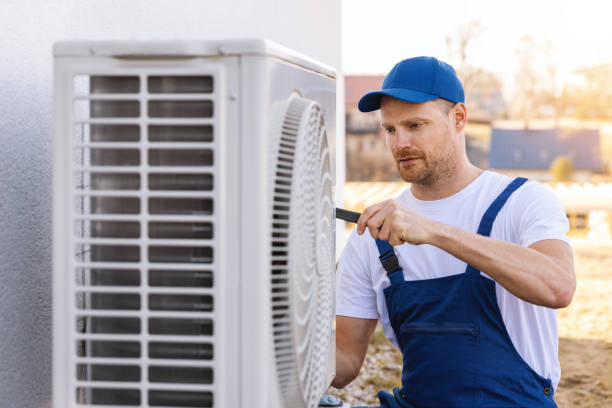 HVAC technician servicing an outdoor air conditioning unit in Salt Lake City