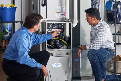 HVAC technician explaining furnace repair and maintenance to a homeowner in Salt Lake City, UT