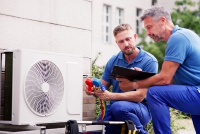 HVAC technicians reviewing an outdoor air conditioning unit in Salt Lake City, UT
