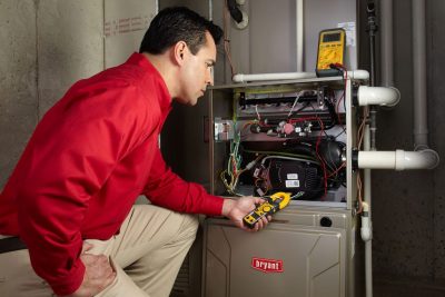 Heating and air conditioning technician servicing an indoor furnace in Salt Lake City, UT